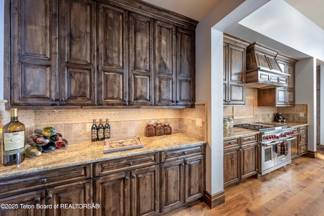 380 Cottongrass Rd, Driggs, ID 83422 - kitchen featuring double oven range, custom range hood, light wood-type flooring, and decorative backsplash