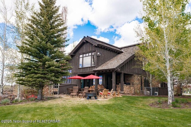 380 Cottongrass Rd, Driggs, ID 83422 - rear view of property with stone siding, a yard, and a patio