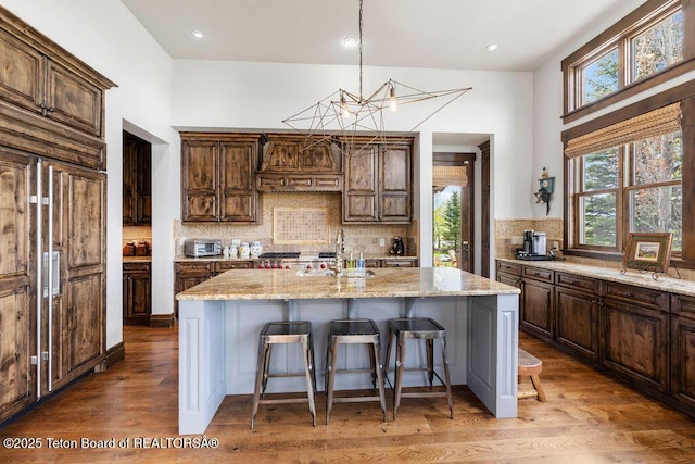 380 Cottongrass Rd, Driggs, ID 83422 - kitchen with a sink, a kitchen breakfast bar, light stone counters, wood finished floors, and recessed lighting
