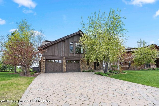 380 Cottongrass Rd, Driggs, ID 83422 - view of front of property featuring stone siding, decorative driveway, and an attached garage
