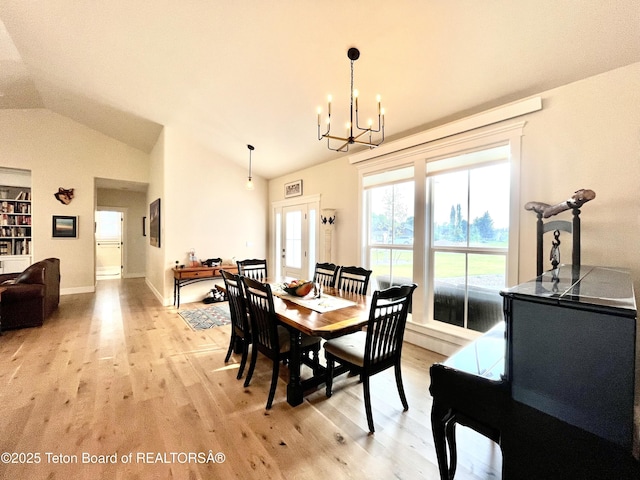 dining room with vaulted ceiling, light hardwood / wood-style floors, and a chandelier