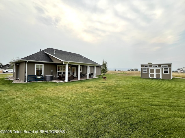 rear view of house with a storage unit, a patio area, and a lawn