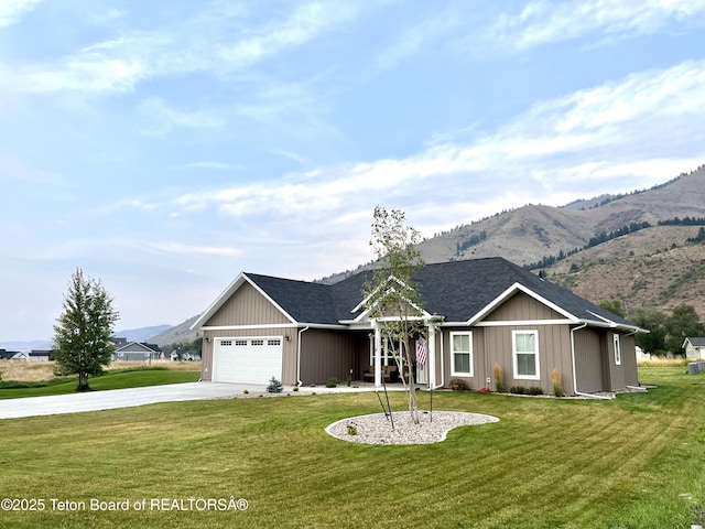 ranch-style house featuring a garage, a mountain view, and a front lawn