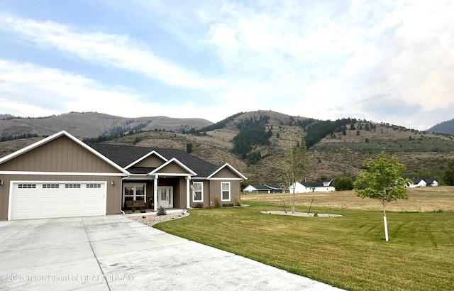 view of front facade featuring a garage, a mountain view, and a front lawn