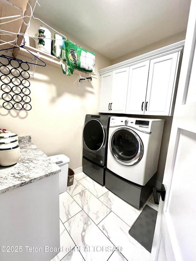 laundry room featuring independent washer and dryer and cabinets