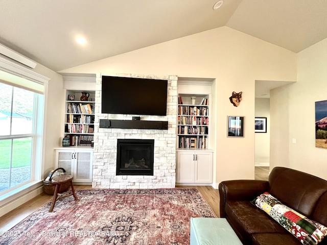 living room featuring wood-type flooring, lofted ceiling, a fireplace, and built in shelves