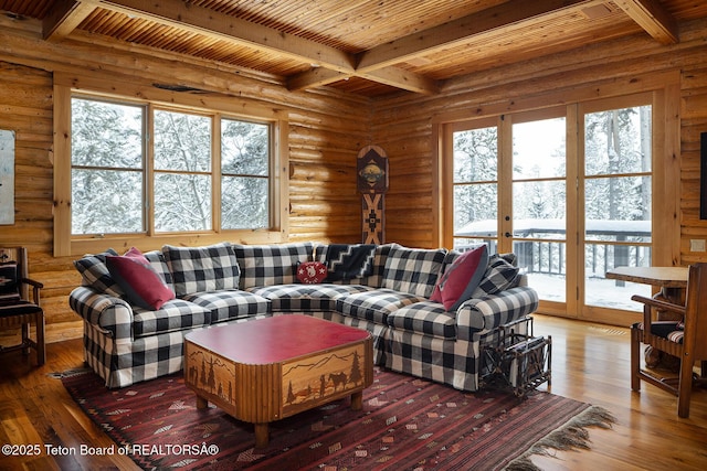 living area featuring wood ceiling, rustic walls, beamed ceiling, and hardwood / wood-style flooring