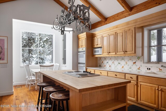 kitchen with butcher block countertops, white appliances, a sink, backsplash, and beam ceiling