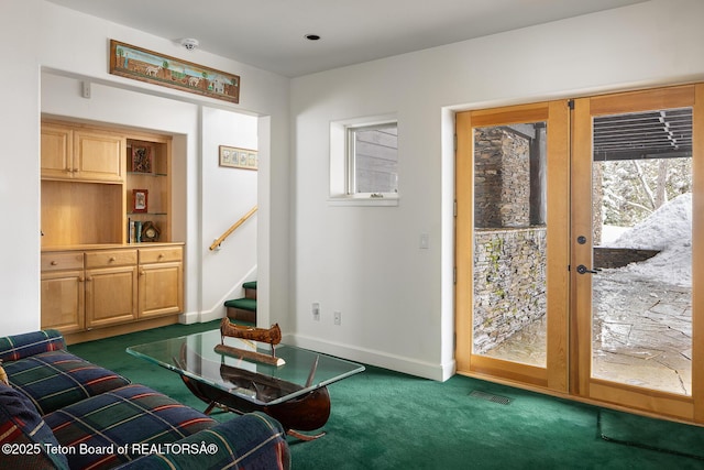 living area featuring french doors, visible vents, dark carpet, baseboards, and stairs