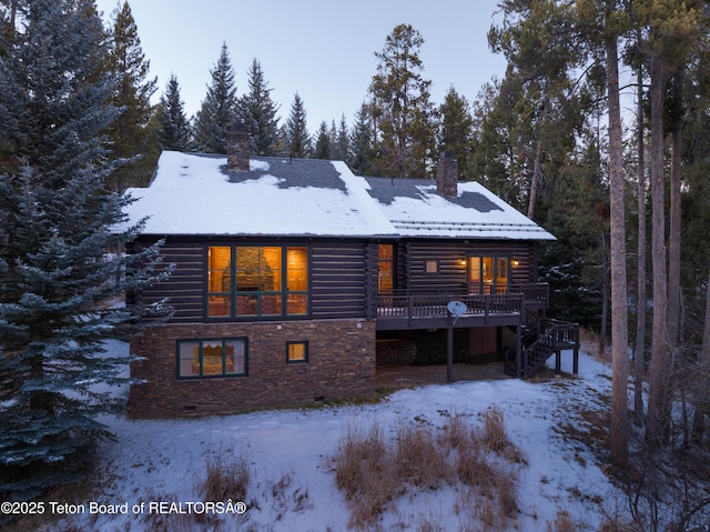 snow covered rear of property with stairs, a chimney, and a deck