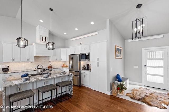 kitchen featuring white cabinetry, stainless steel appliances, and a breakfast bar area