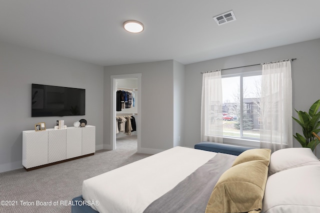 carpeted bedroom with a spacious closet