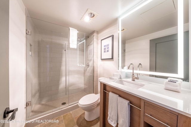 bathroom with toilet, vanity, and a shower with shower door