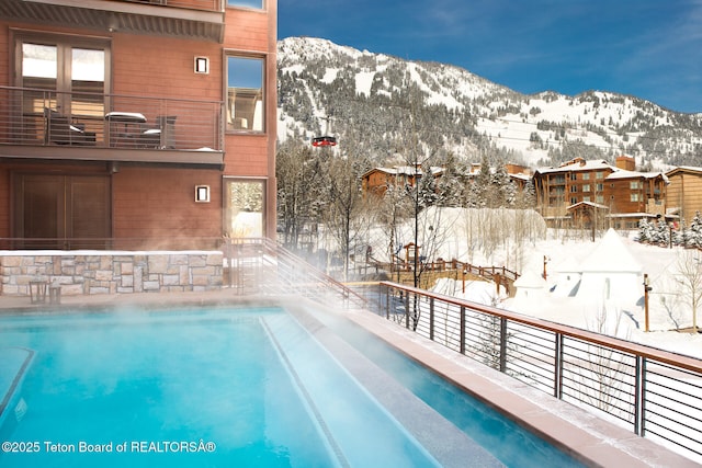 snow covered pool featuring a mountain view