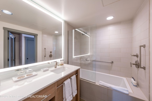 bathroom featuring tiled shower / bath and vanity