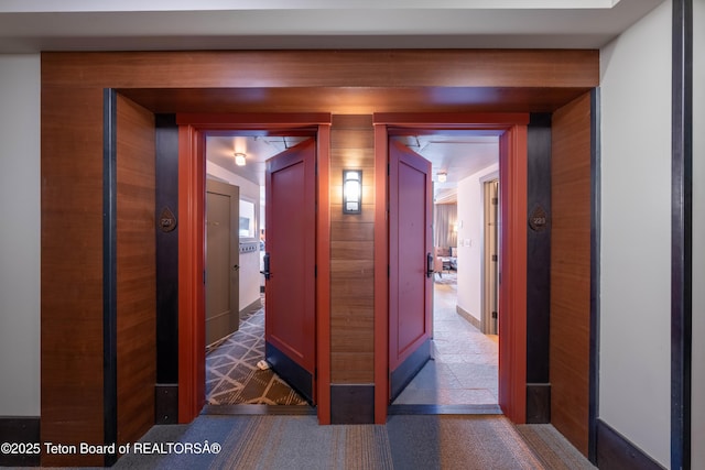 hallway featuring dark colored carpet