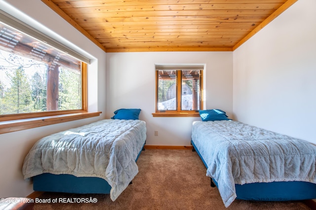 bedroom featuring lofted ceiling, multiple windows, wooden ceiling, and carpet flooring