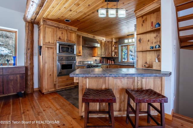 kitchen with open shelves, stainless steel appliances, wood ceiling, ventilation hood, and a kitchen breakfast bar