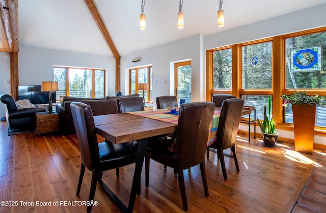 dining room featuring lofted ceiling with beams and hardwood / wood-style flooring