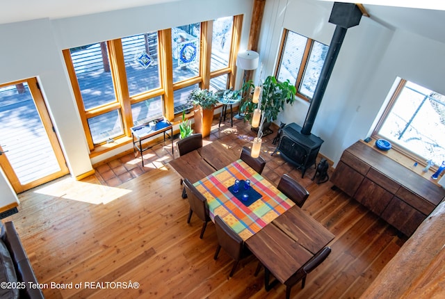 dining area with a wood stove and wood finished floors