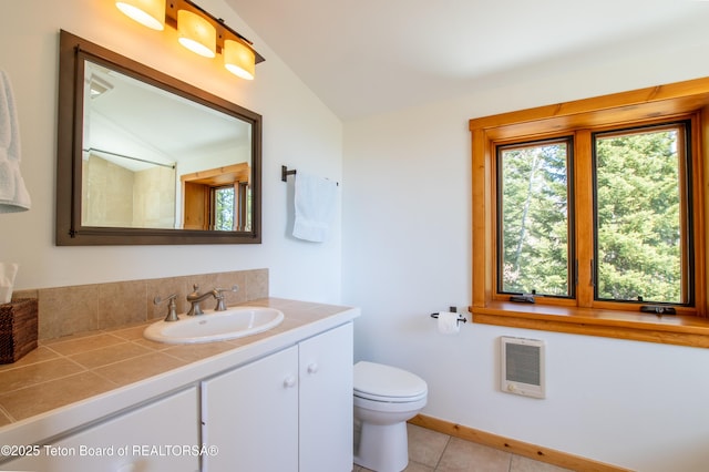 bathroom with tile patterned flooring, toilet, vanity, vaulted ceiling, and heating unit