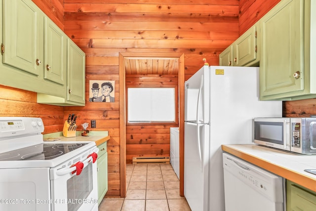 kitchen with light tile patterned floors, white appliances, wooden walls, and green cabinets