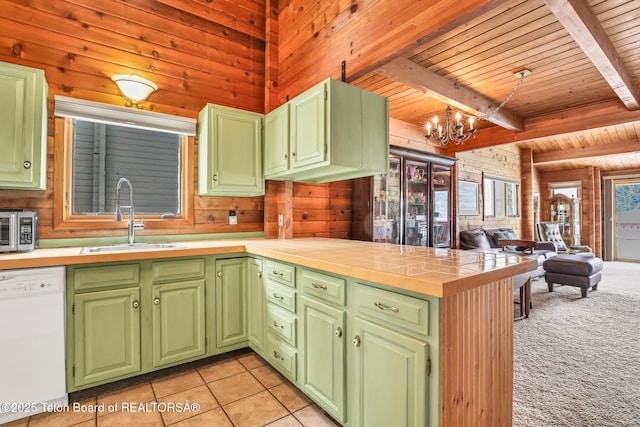 kitchen featuring sink, wood walls, wood ceiling, white dishwasher, and green cabinets