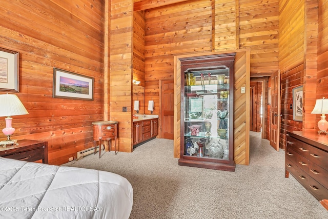 carpeted bedroom featuring a towering ceiling, baseboard heating, and wood walls