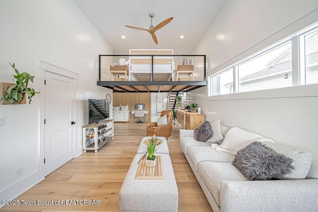 living room featuring high vaulted ceiling, light hardwood / wood-style floors, and ceiling fan