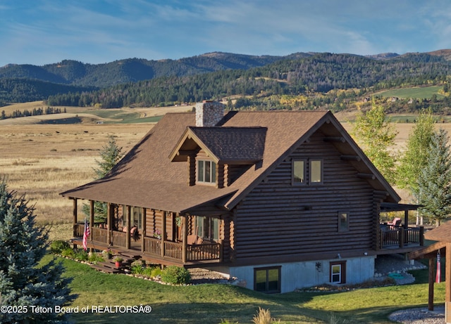 6352 W 1170 N, Driggs, ID 83442 - view of front of house with log siding, a mountain view, a chimney, and a front lawn