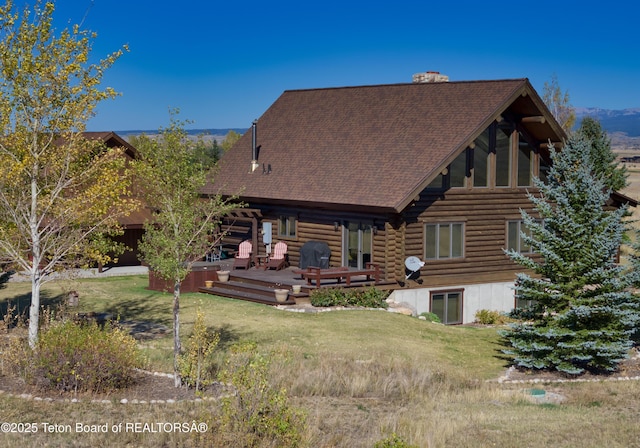6352 W 1170 N, Driggs, ID 83442 - rear view of house featuring a deck, a shingled roof, log siding, and a yard