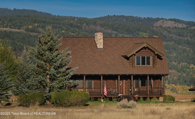 6352 W 1170 N, Driggs, ID 83442 - log cabin with a forest view, a chimney, log siding, and roof with shingles