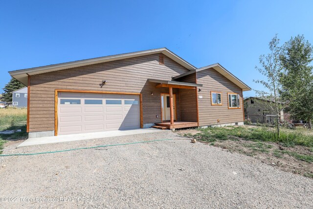 view of front facade featuring a garage, driveway, and fence