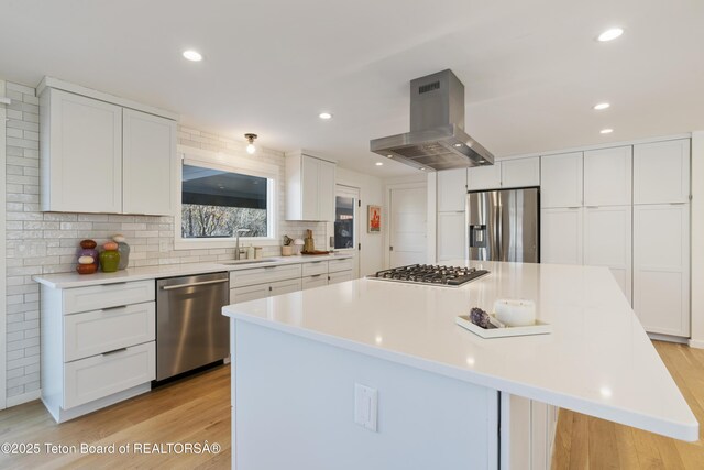 725 Cache Creek Dr, Jackson, WY 83001 - kitchen with a kitchen island, appliances with stainless steel finishes, white cabinetry, sink, and island exhaust hood