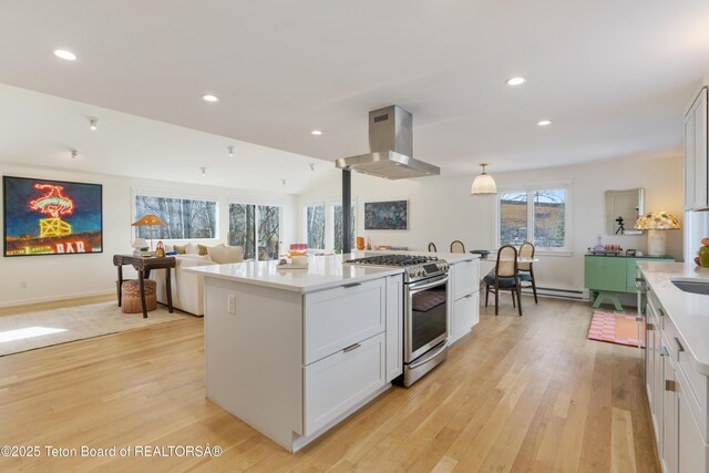 725 Cache Creek Dr, Jackson, WY 83001 - kitchen with gas stove, a center island, island exhaust hood, light hardwood / wood-style floors, and white cabinets