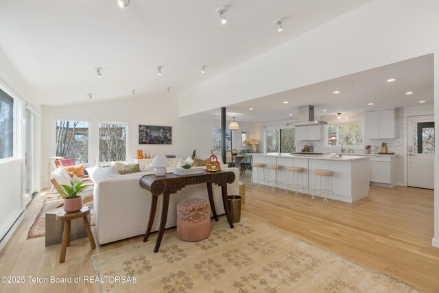 725 Cache Creek Dr, Jackson, WY 83001 - living room featuring vaulted ceiling, plenty of natural light, light hardwood / wood-style floors, and baseboard heating