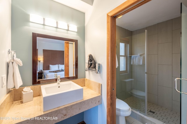 bathroom with sink, an enclosed shower, and toilet