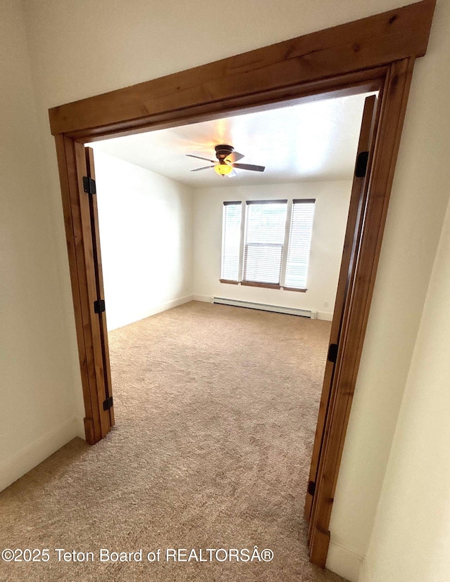 carpeted empty room with a baseboard radiator and ceiling fan