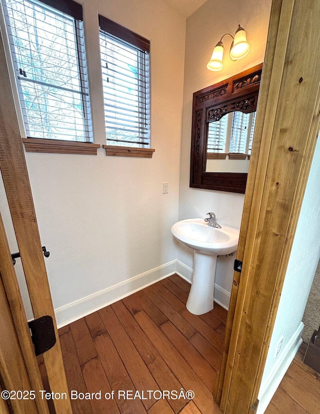 bathroom featuring a healthy amount of sunlight, baseboards, and hardwood / wood-style flooring