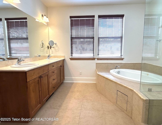 bathroom featuring a sink, a bath, double vanity, and tile patterned floors