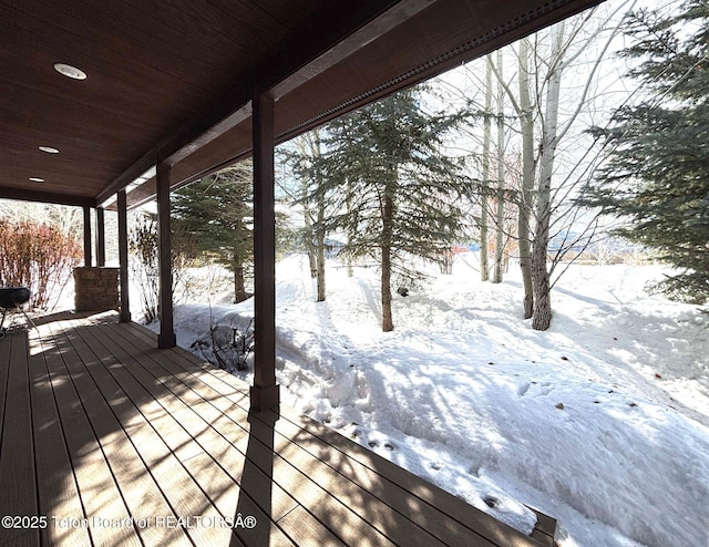 snow covered deck featuring covered porch