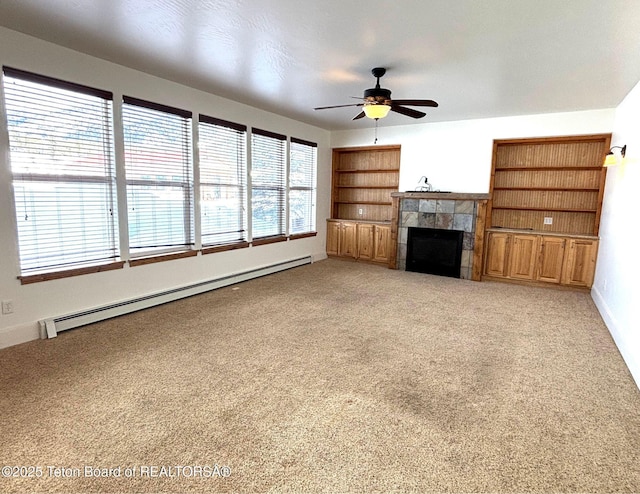 unfurnished living room featuring built in shelves, ceiling fan, light colored carpet, baseboard heating, and a fireplace