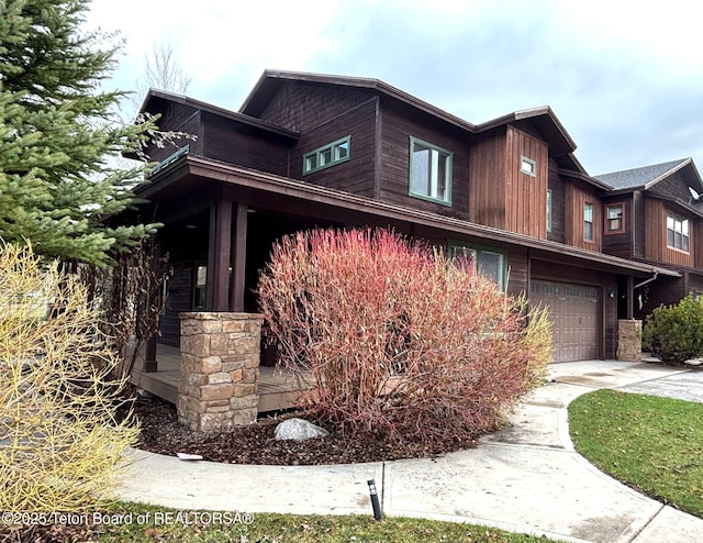 view of side of home with concrete driveway and an attached garage
