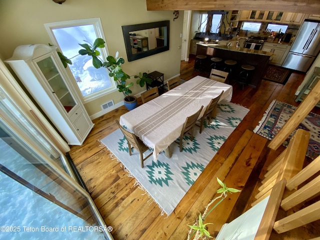 dining area featuring wood finished floors, visible vents, and baseboards