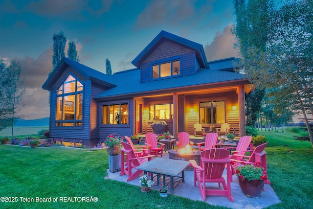 15 Kearsley Ln, Victor, ID 83455 - back of house at dusk with a fire pit, a lawn, and a patio