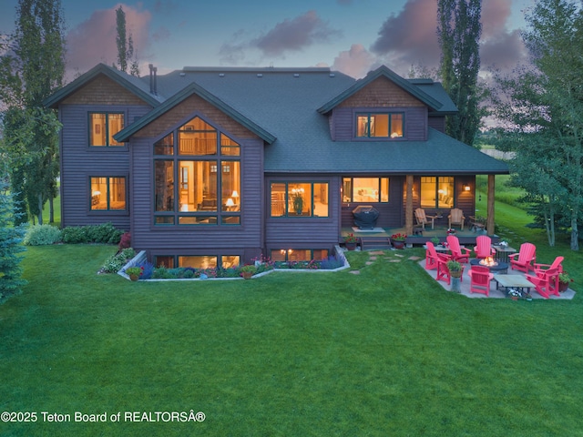15 Kearsley Ln, Victor, ID 83455 - rear view of house featuring a patio, a yard, a fire pit, and a shingled roof