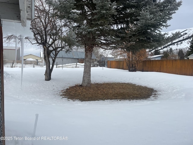 yard covered in snow with fence