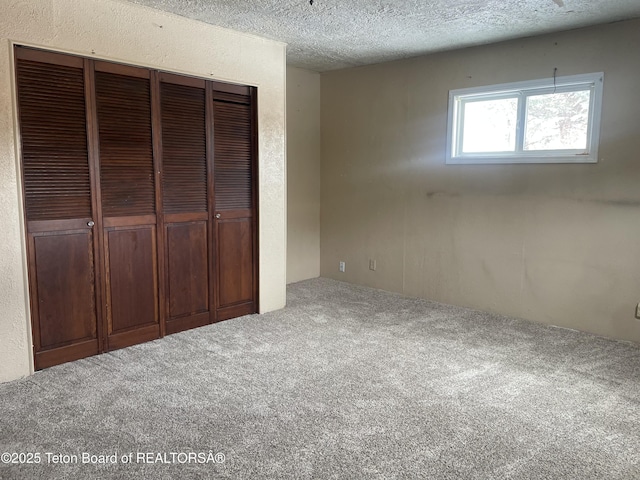 unfurnished bedroom featuring a closet, carpet flooring, and a textured ceiling