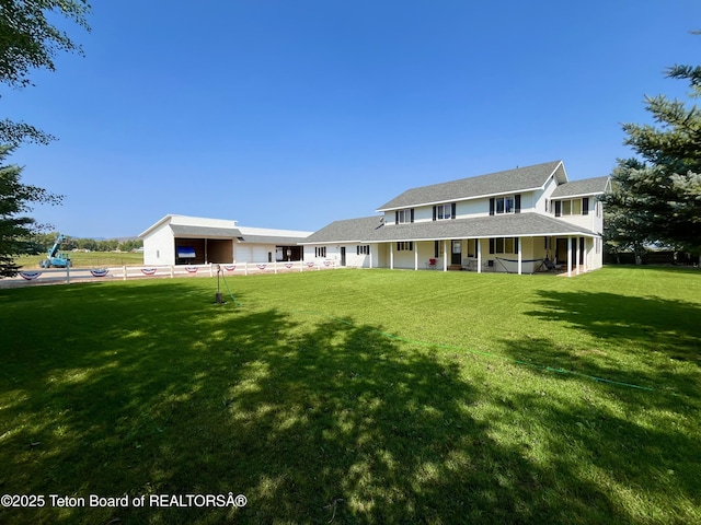 rear view of property with a yard and fence