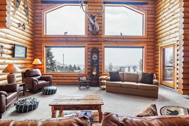 living area with rustic walls, a high ceiling, and carpet flooring